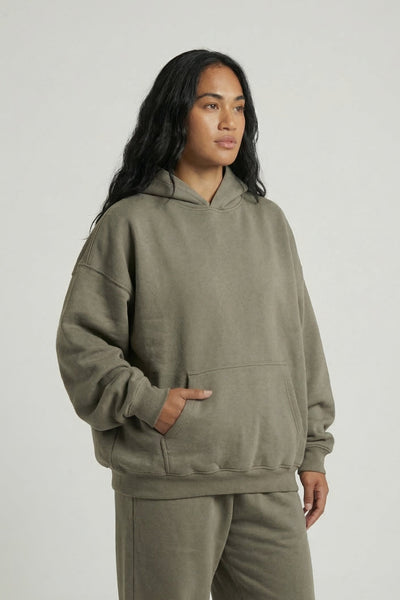 Person wearing a green tracksuit on a plain background