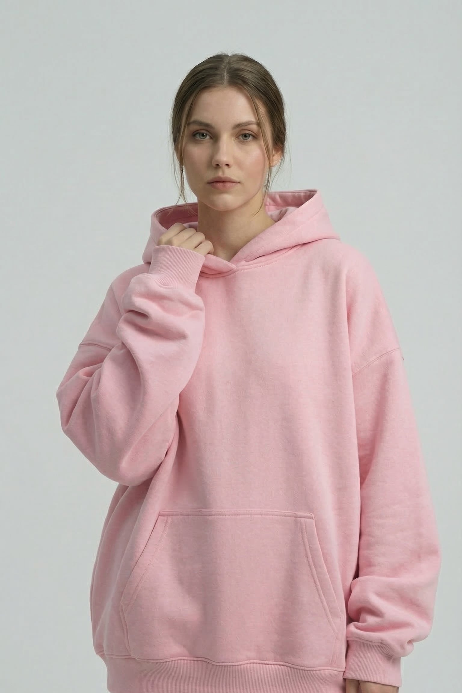 Person wearing a pink hoodie and pants on a plain background
