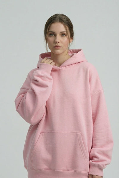 Person wearing a pink hoodie and pants on a plain background