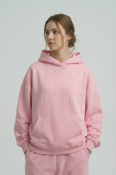 Person wearing a pink hoodie and pants on a plain background