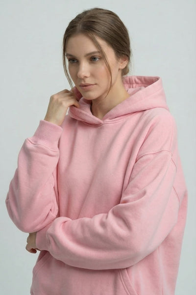 Person wearing a pink hoodie against a plain background