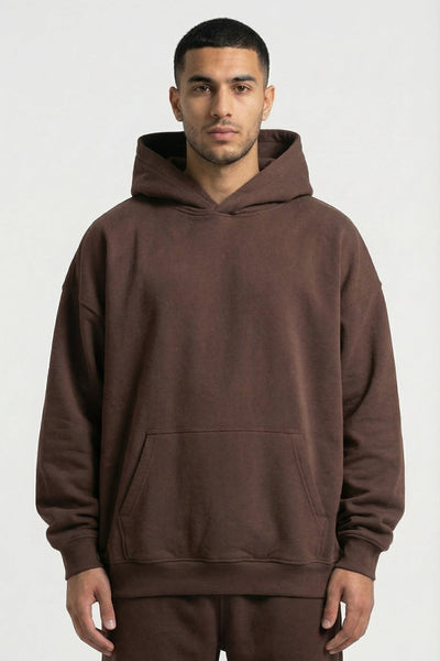 Man wearing a brown hoodie and pants on a white background