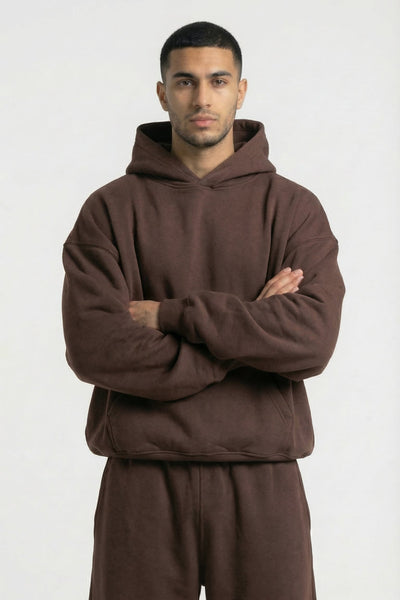 Man wearing a brown hoodie and pants on a white background