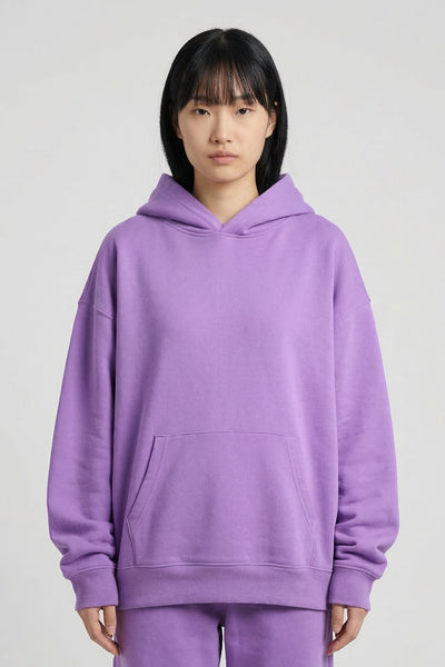 Person wearing a purple hoodie and pants on a white background
