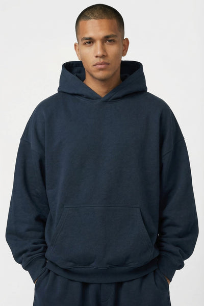 Man wearing a navy blue hoodie and pants on a white background