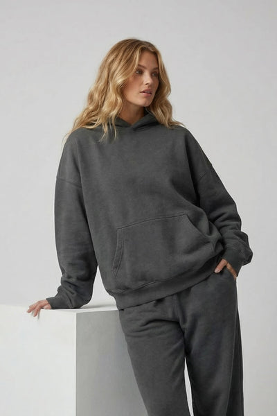 Woman wearing a gray tracksuit against a white background