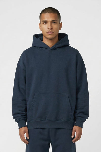 Man wearing a navy blue hoodie and pants set on a white background