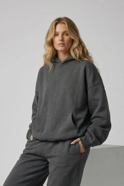 Woman wearing a gray tracksuit against a plain background