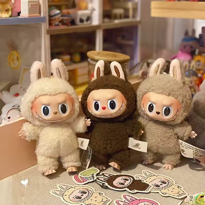 Set of three plush monster vinyl-face figures in cream, brown, and tan