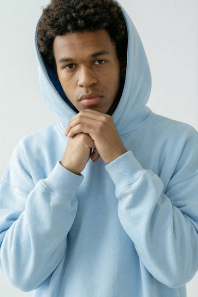 Person wearing a light blue hoodie against a white background