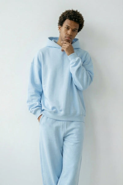 Person wearing a light blue tracksuit against a white background