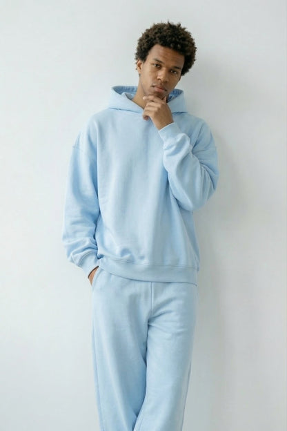 Person wearing a light blue tracksuit against a white background