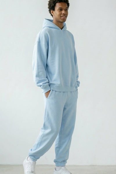 Person wearing a light blue tracksuit against a white background