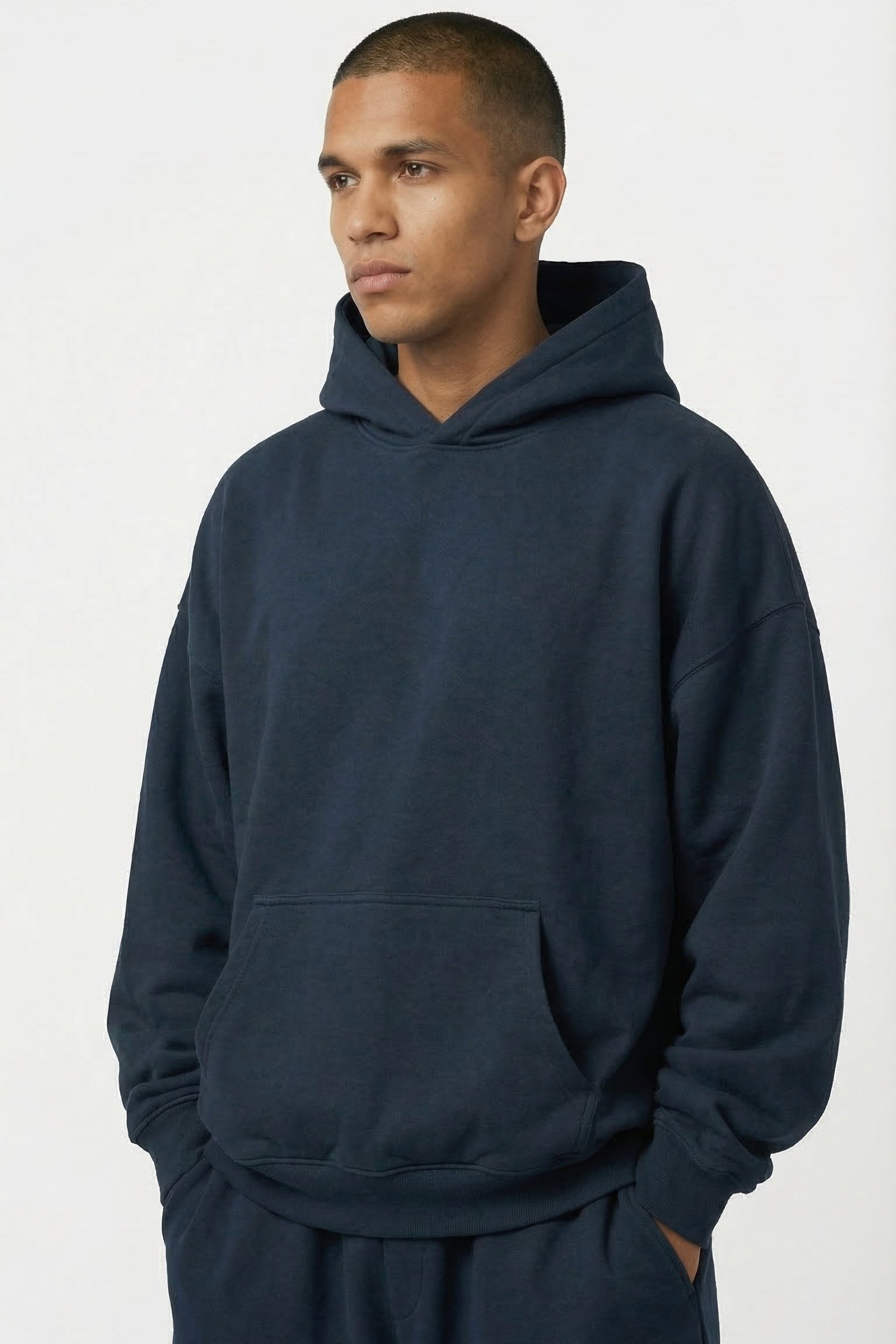 Man wearing a navy blue hoodie and pants on a white background