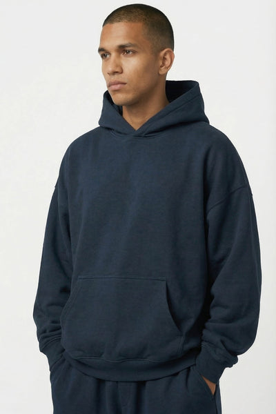 Man wearing a navy blue hoodie and pants on a white background