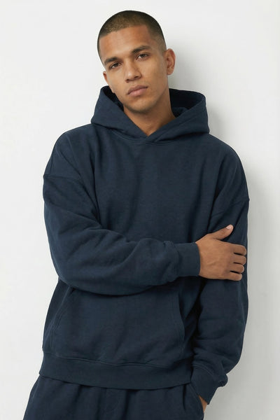 Man wearing a navy blue hoodie and pants against a white background