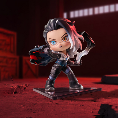 A stylized chibi figurine of Fade character with black and pink hair, blue and amber eyes, wearing a dark futuristic outfit, posed on a reflective black base against a dark red and black background.