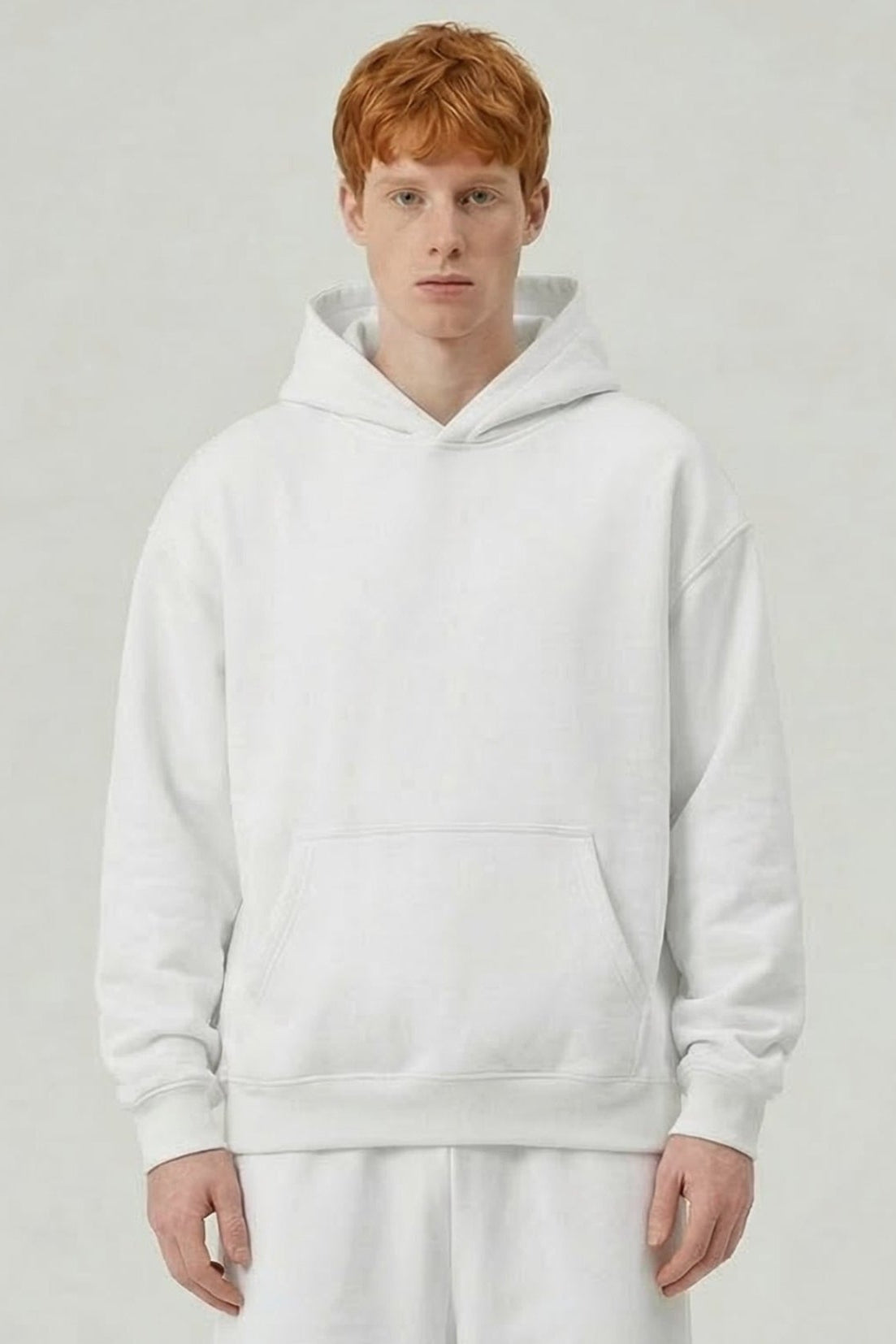 Person wearing a white hoodie and pants on a plain background
