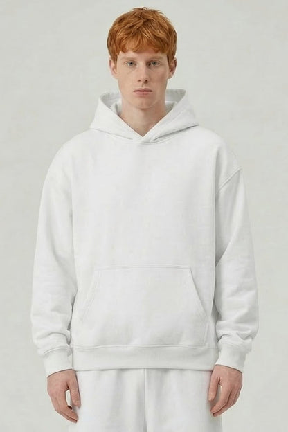 Person wearing a white hoodie and pants on a plain background