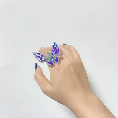 Butterfly ring with blue enamel wings and silver band on hand