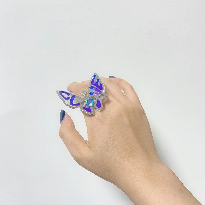 Butterfly ring with blue enamel wings and silver band on hand