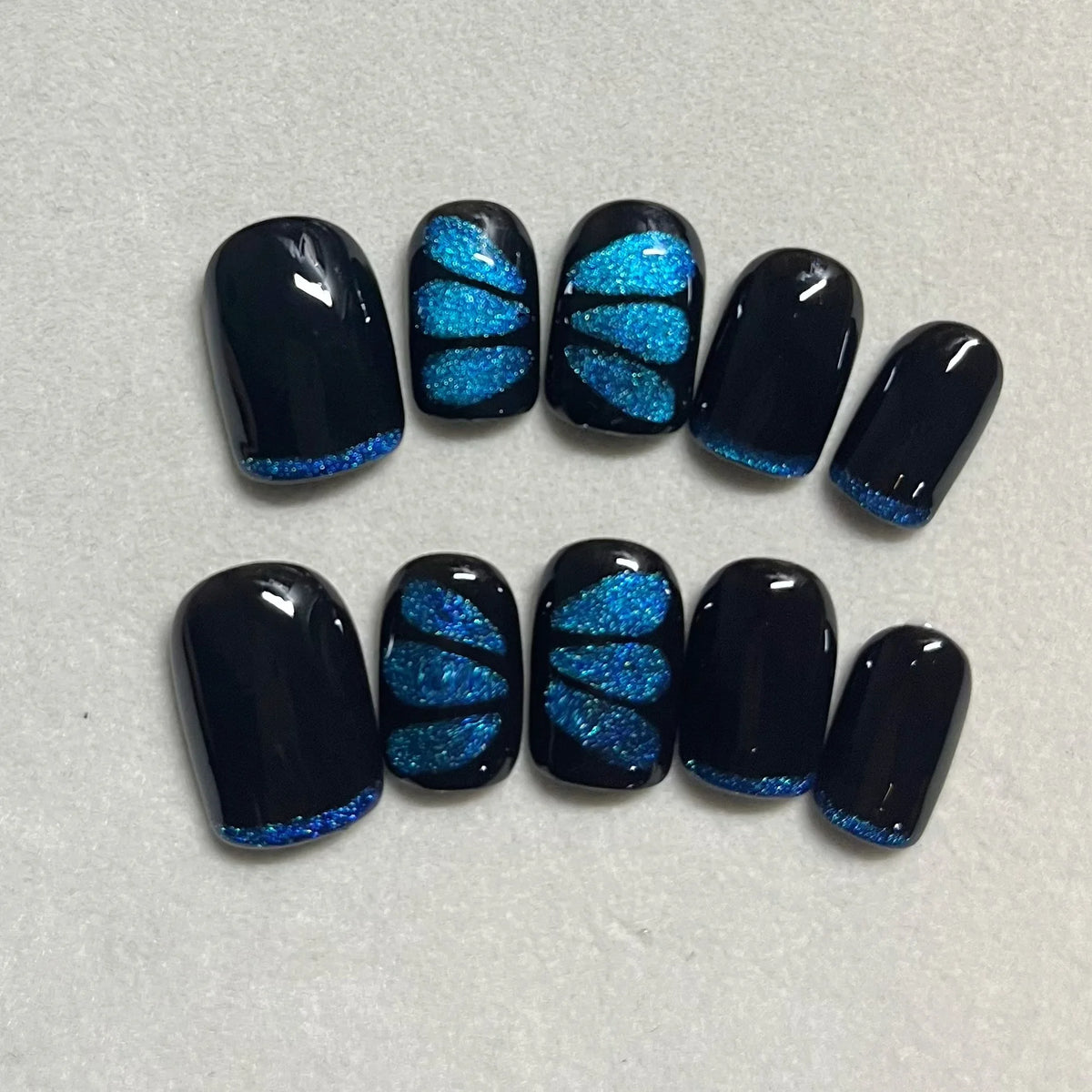 Press-on false nails: dark navy with blue glitter butterfly designs