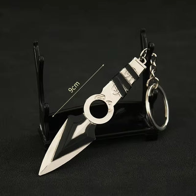 Kunai knife keychain with circular ring and striped black handle, on display