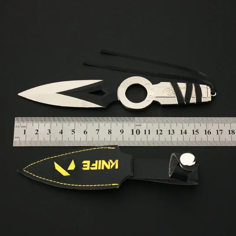 Kunai knife keychain with white blade, silver ring, black sheath, and yellow logo tag
