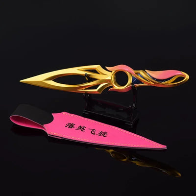 Kunai knife with pink sheath and gold blade, multicolor center ring and pointed tip