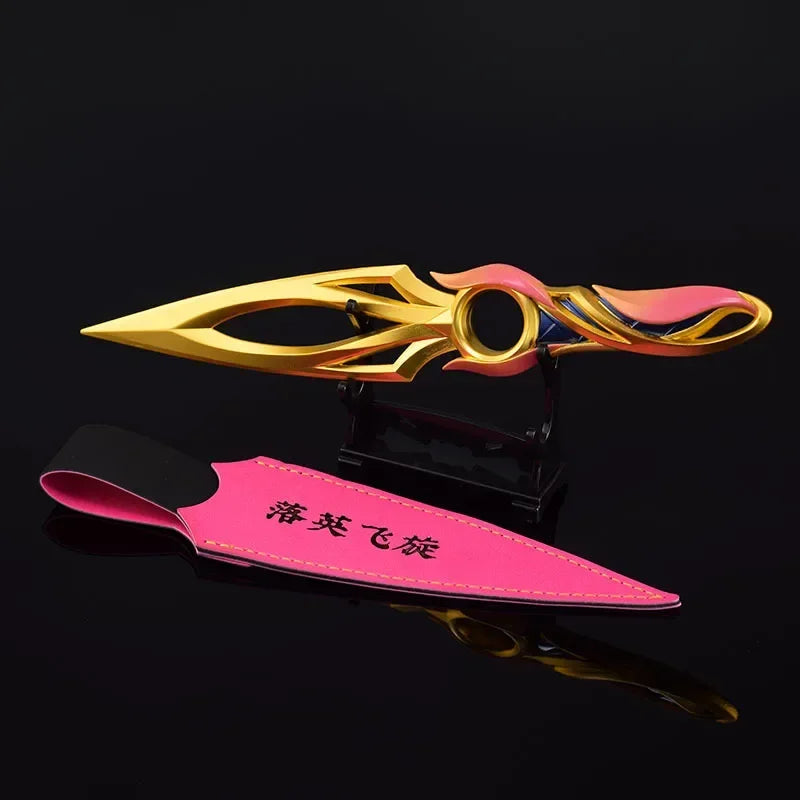 Kunai knife with pink sheath and gold blade, multicolor center ring and pointed tip