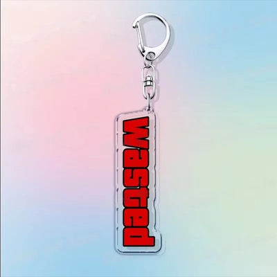 Acrylic keychain with a clear tag and bold red vertical lettering design