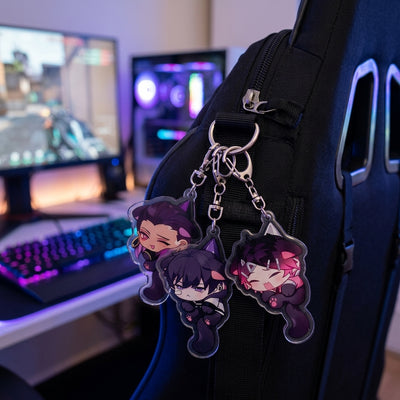 Chibi cat-ear acrylic keychains on a black backpack strap with metal rings.