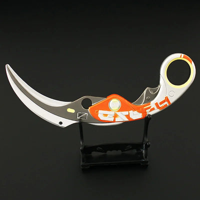 Karambit knife with orange handle, black accents, and finger ring loop